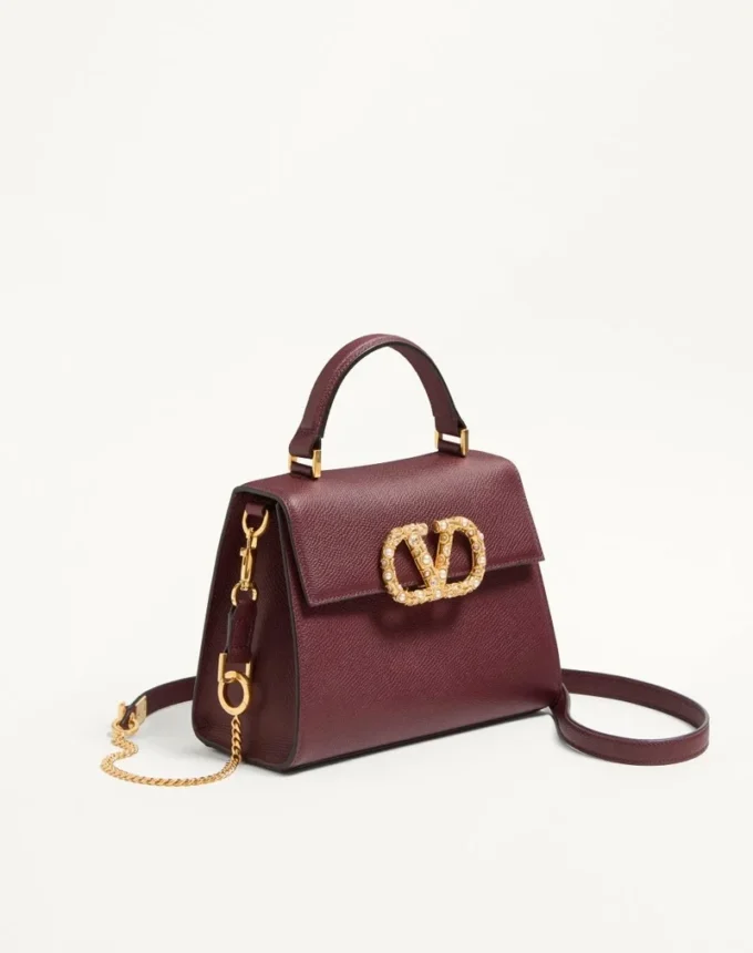 Geantă de mână Valentino Garavani Vsling din piele de vițel granată cu logo bijuterie Geantă de mână Valentino Garavani Vsling din piele de vițel granată cu logo bijuterie
