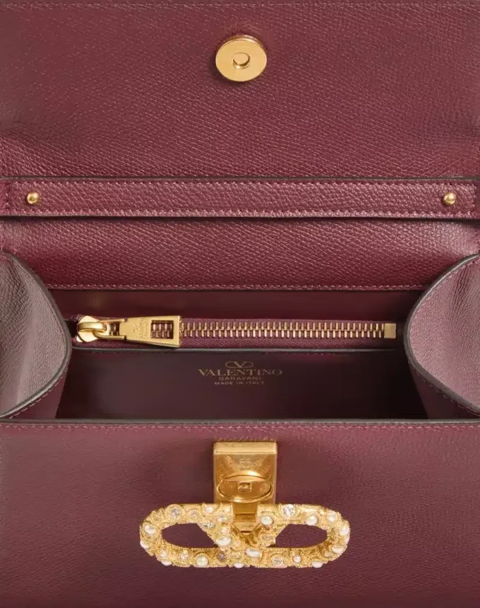 Geantă de mână Valentino Garavani Vsling din piele de vițel granată cu logo bijuterie Geantă de mână Valentino Garavani Vsling din piele de vițel granată cu logo bijuterie