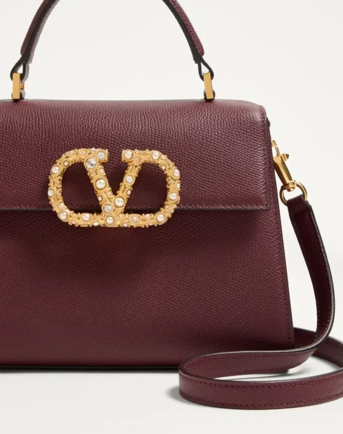 Geantă de mână Valentino Garavani Vsling din piele de vițel granată cu logo bijuterie Geantă de mână Valentino Garavani Vsling din piele de vițel granată cu logo bijuterie