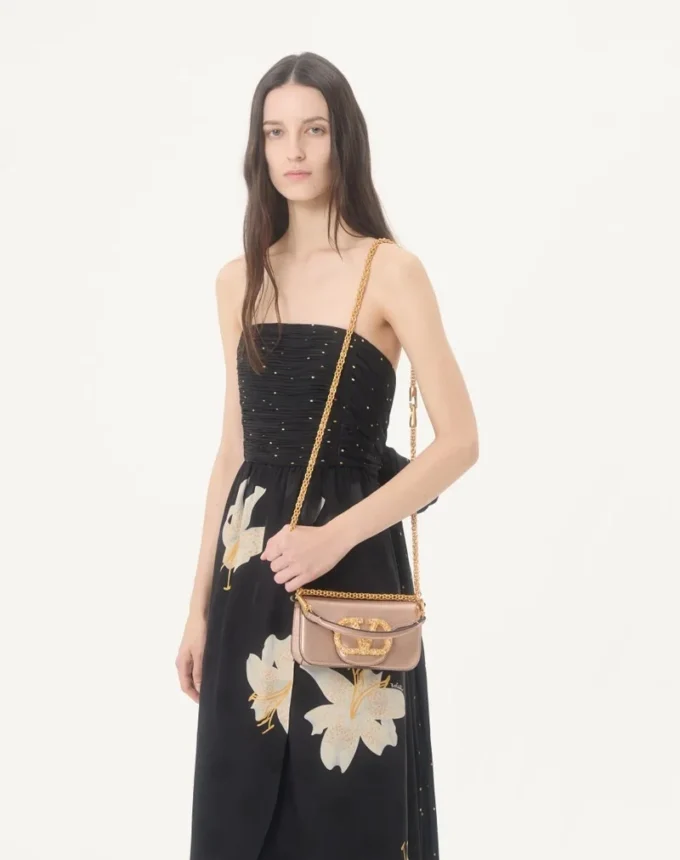 Geantă mică de umăr Valentino Garavani Locò din piele de vițel laminată cu logo bijuterie Geantă mică de umăr Valentino Garavani Locò din piele de vițel laminată cu logo bijuterie