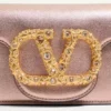 Geantă mică de umăr Valentino Garavani Locò din piele de vițel laminată cu logo bijuterie Geantă mică de umăr Valentino Garavani Locò din piele de vițel laminată cu logo bijuterie