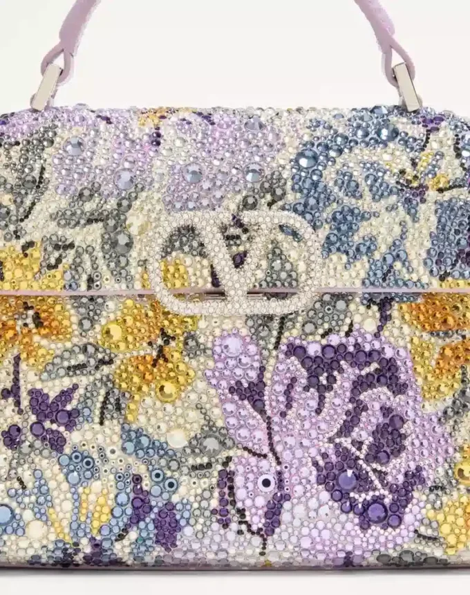 Mini geantă de mână Valentino Garavani Vsling cu motiv Flowerism din strasuri și logo bijuterie Mini geantă de mână Valentino Garavani Vsling cu motiv Flowerism din strasuri și logo bijuterie