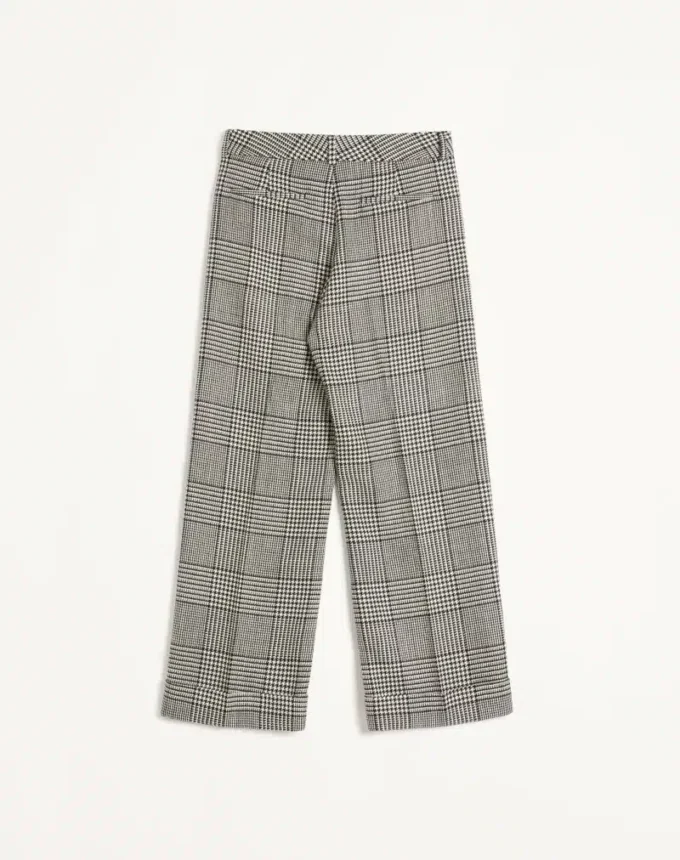Pantaloni din lână cu revere și model în carouri pe fundal houndstooth
