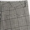 Pantaloni din lână cu revere și model în carouri pe fundal houndstooth