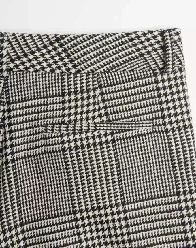Pantaloni din lână cu revere și model în carouri pe fundal houndstooth